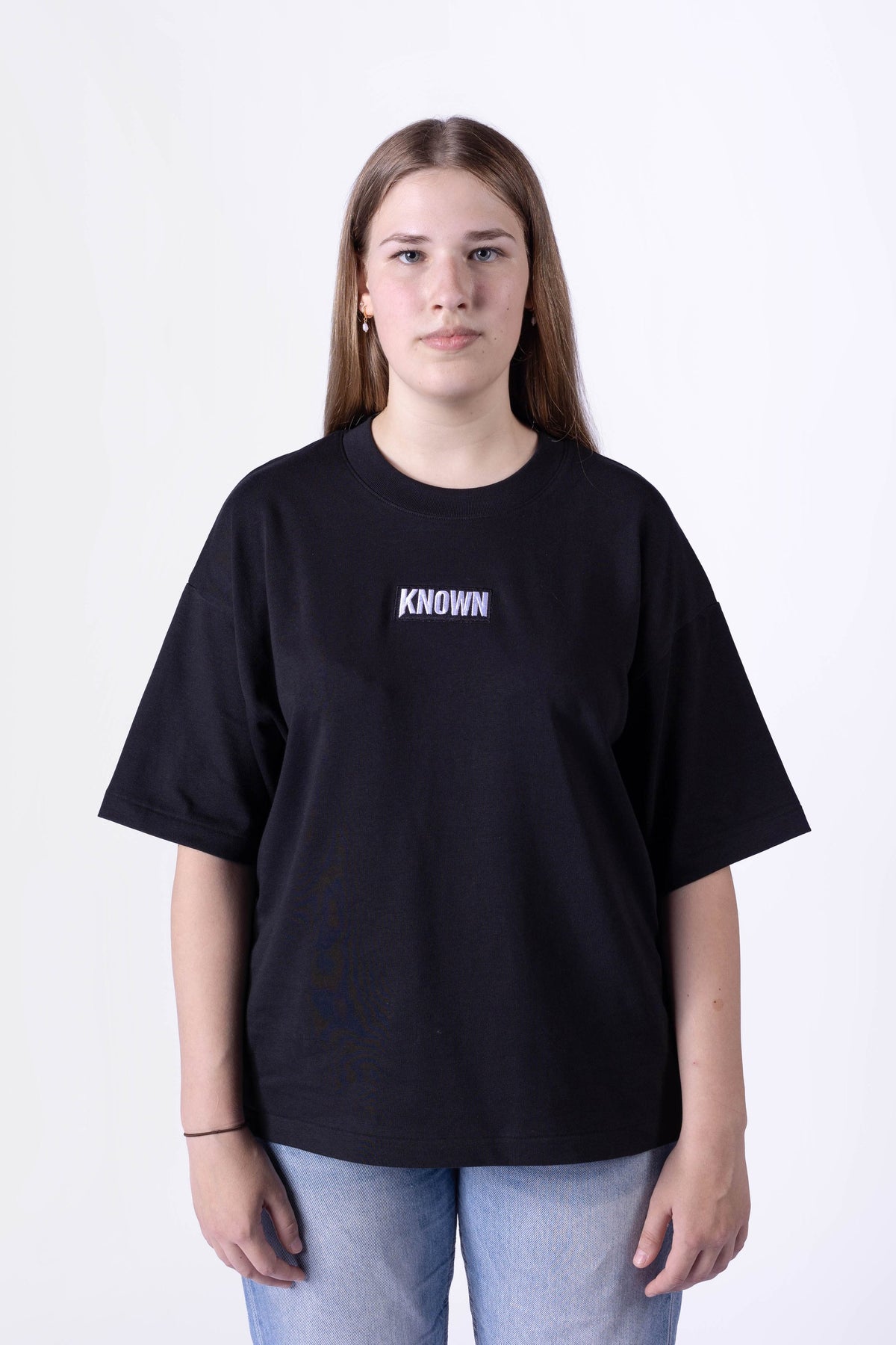 Schwarzes T-Shirt von KNOWN, getragen von weiblichem Model